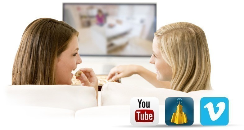 Two women sit on sofa to watch YouTube Dailymotion Vimeo videos on TV